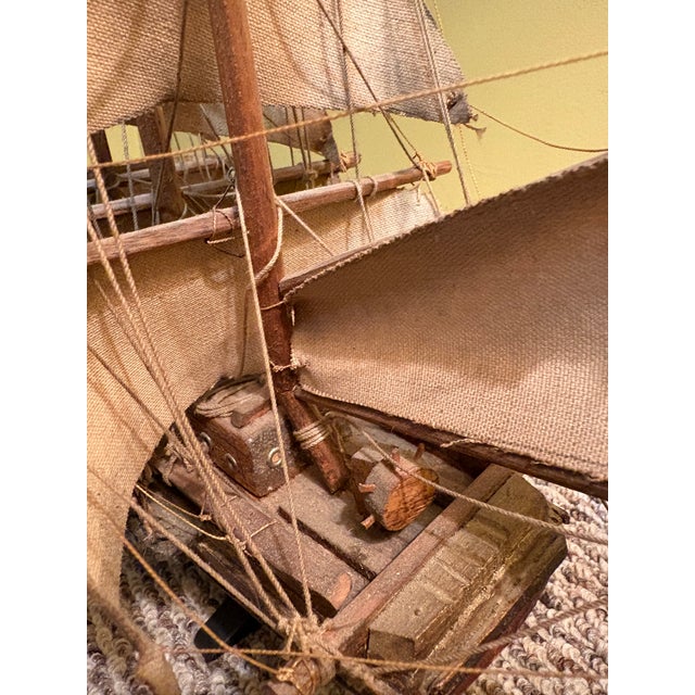 Vintage handcrafted 3 masted wooden ship model with fabric sails. It features intricate rigging and deck details, mounted...