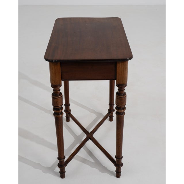 A 19th century French side table featuring a rectangular top supported by a simple wooden frame with stretcher detail. The...
