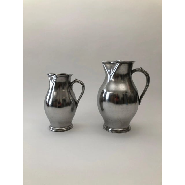 A set of two pewter wine jugs from the Wiener Zin manufacture ,dated 1837. These polished pewter wine jugs exhibit...