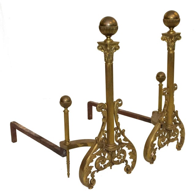 These vintage andirons of brass and iron are an attractive pair. The Neoclassical- inspired decorative features include;...