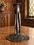 Three tall, open supports connect a wide circular foot to the candle socket, with looping Celtic decoration spreading...