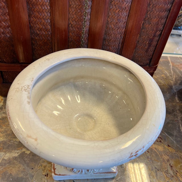 White Pedestal Base Urn Planter Cute distressed white urn planter. It features a circular body on a pedestal base....