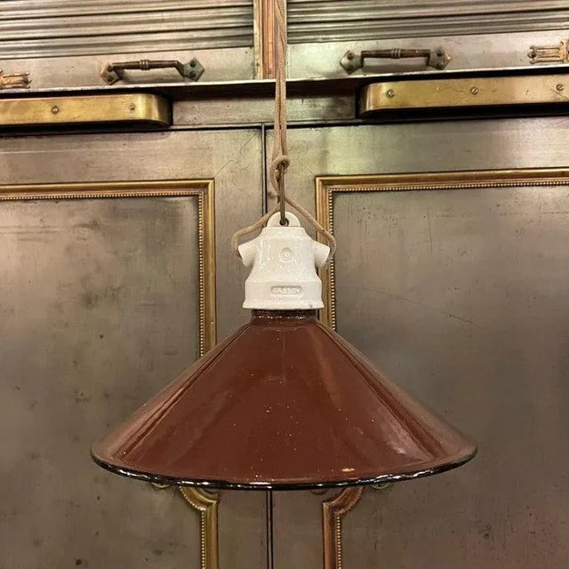 Early 20th century, industrial, factory pendant light with brown enameled, cone shape, metal shade and porcelain fitter is...