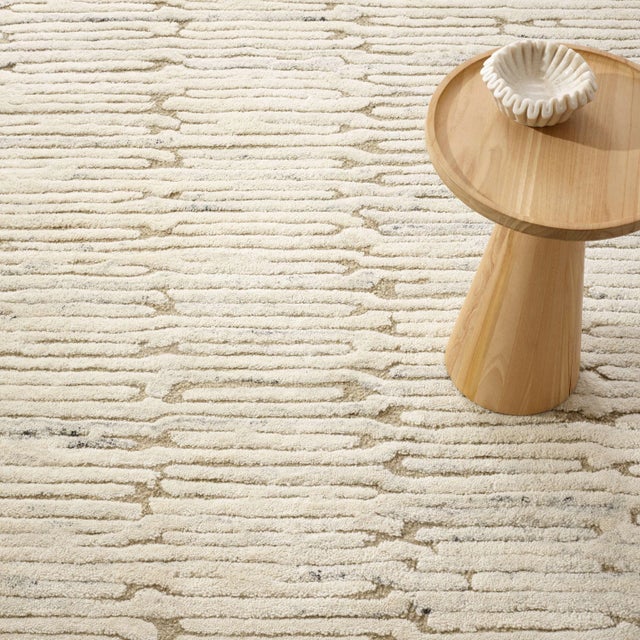 Luxuriously plush, this wool rug's subtle beauty suggests eroded coastal cliffs, whose substrate layers chronicle the...