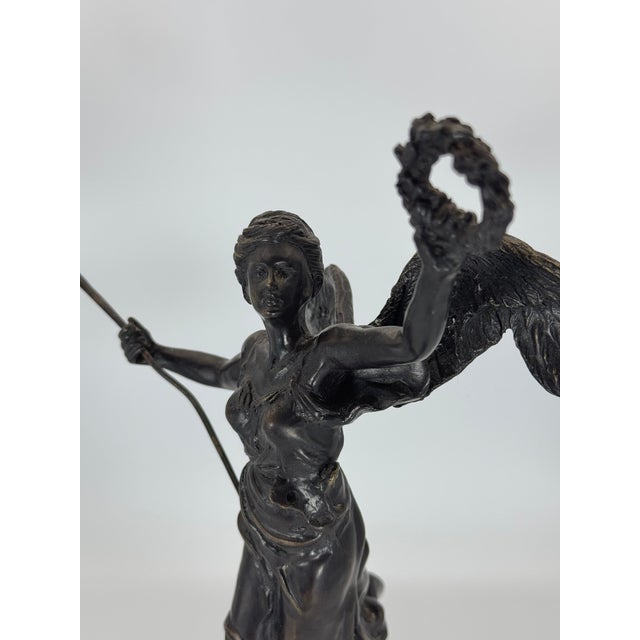 Elevate your collection with this striking bronze winged victory figurine, an elegant and timeless piece that embodies...