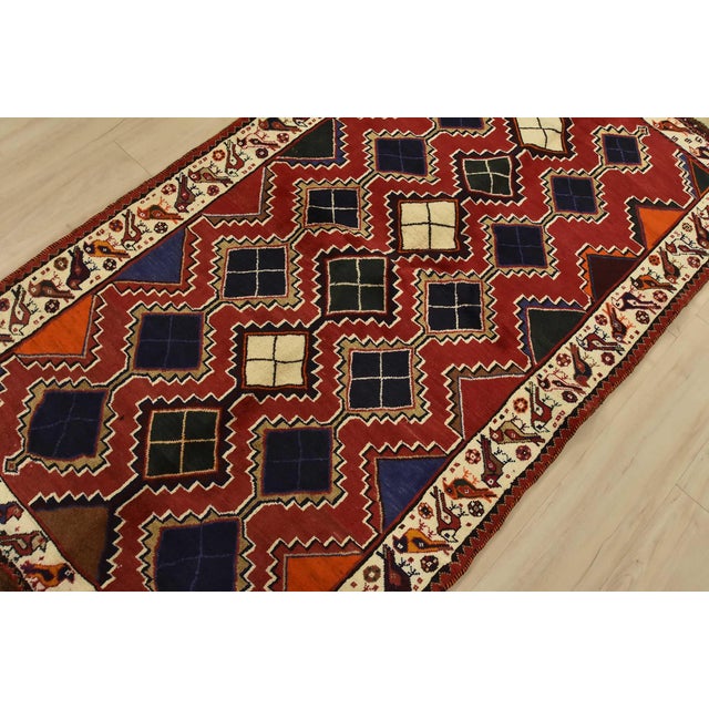 An authentic vintage tribal Qashqai rug hand-knotted with fine wool and natural dyes. This nomadic rug features a...