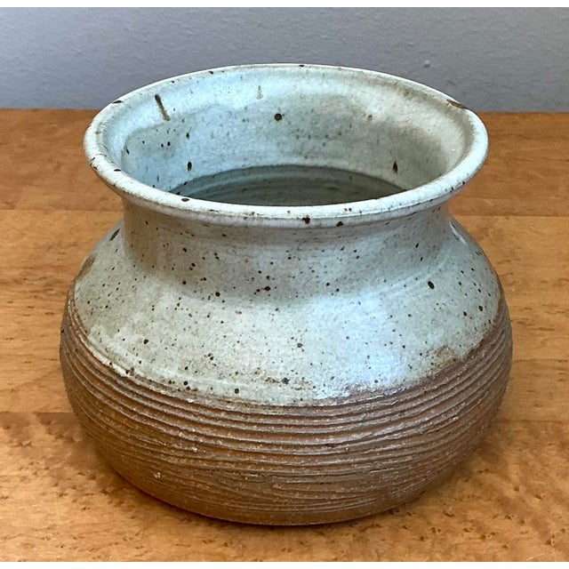 This masterfully crafted studio pottery vessel captures the essence of organic modern design through a compelling play of...