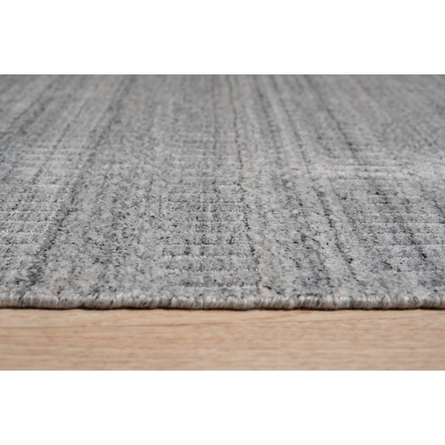 Tessa Xena Silver Handmade Wool Rug, Country of Origin: India. This sophisticated piece presents a minimalist aesthetic,...