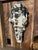 Very large longhorn skull sculpture in black, cream, silver and gold, an artist's meditation on the Buddhist tenet of...