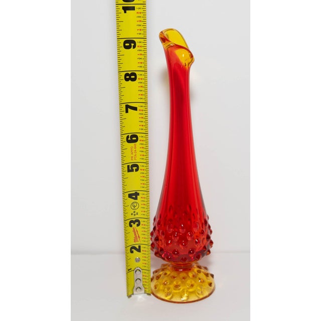 Hand-stretched swung vase rising from a hobnail base in amberina glass, graduating from ruby red at the rim to golden...