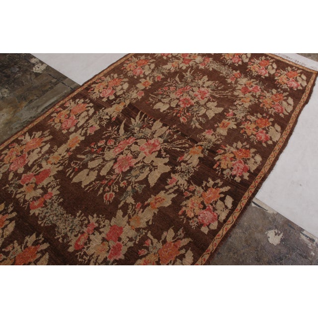 Hand-knotted in wool pile originating from Turkey circa 1950-1960, this vintage rug connotes a mid-century Bessarabian rug...