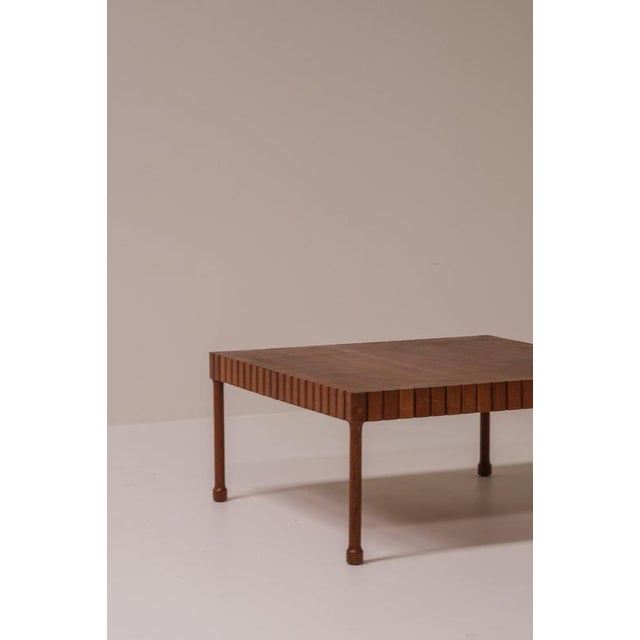 A beautifully made square coffee table from the 1960s–1970s, constructed entirely in solid wood and defined by its unusual...