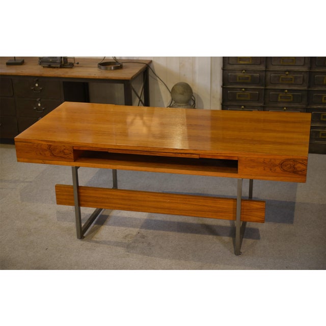 Large "Minister" desk in wood (veneer with pronounced grain), typical of 1970s French design. Generous, glossy top rests...