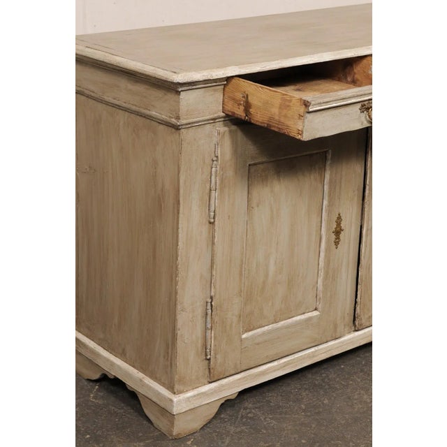 A French two-door painted wood buffet cabinet from the 19th century. This antique cabinet from France has a rectangular-...