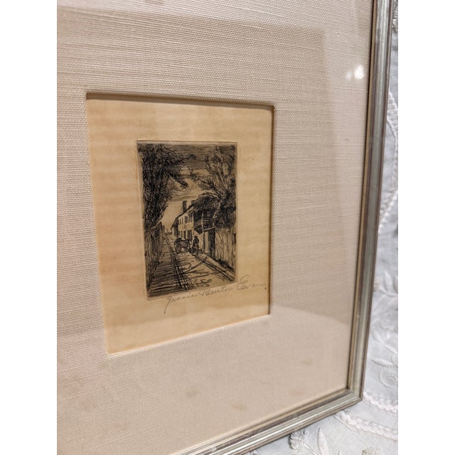 An original etching by American artist depicting a quiet, atmospheric street scene framed by vernacular architecture and...