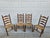 A set of four vintage wooden ladder-back side or dining chairs featuring woven rush seats and turned legs with a centered...