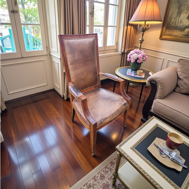 An elegant and timeless antique English armchair, reflecting the refined craftsmanship of early 20th-century British...