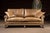 Three-seat sofa upholstered in warm, distressed brown leather with a naturally worn, crackled surface that highlights the...