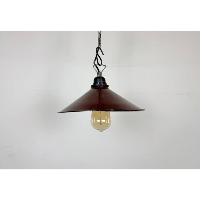Industrial dark red enamel factory pendant light made in Poland during the 1960s. White enamel inside the shade. The...