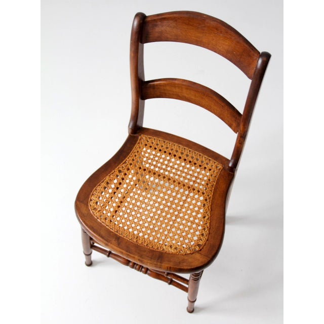 This antique Victorian cottage chair dates to the late 19th century and features a gently curved back with shaped...