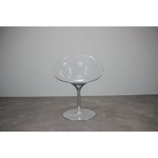 The chair features the characteristic sculptural transparent polycarbonate shell of the eros series, combined with a sleek...