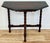 Vintage carved wood demilune table featuring angular beveled top and three bobbin legs attached by carved stretchers....