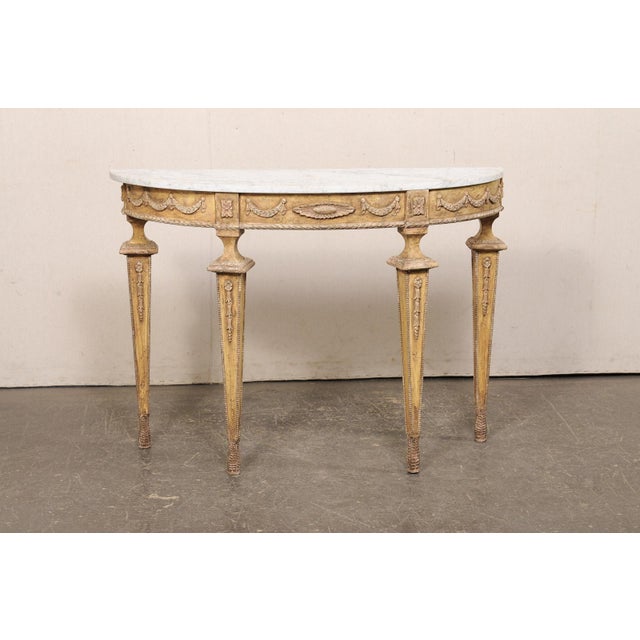 An Italian painted wood console table, with white marble top, from the mid 20th century. This vintage table from Italy has...