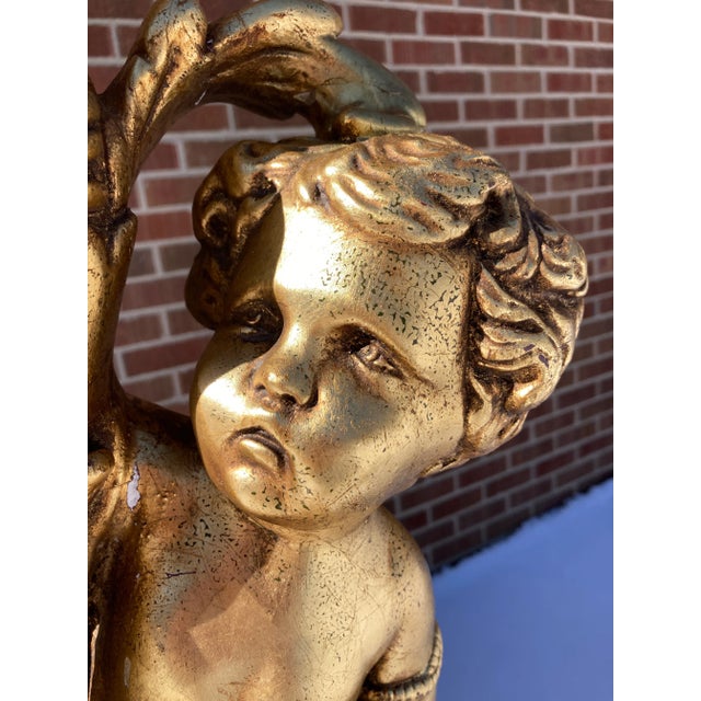 Vintage hollywood regency neoclassical revival plaster gilt cherub putti figural table lamp, atop heavily gilded faux...