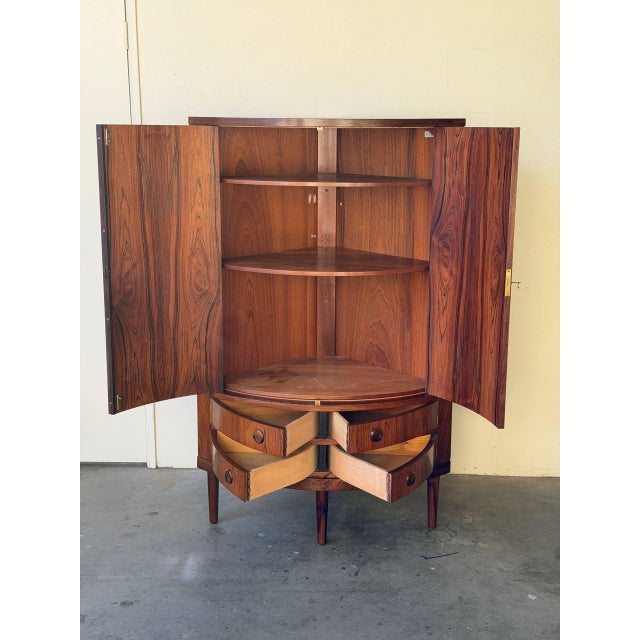 Elegant Mid Century Modern Danish corner cabinet in style of Kai Kristiansen, crafted in warm rosewood with beautifully...