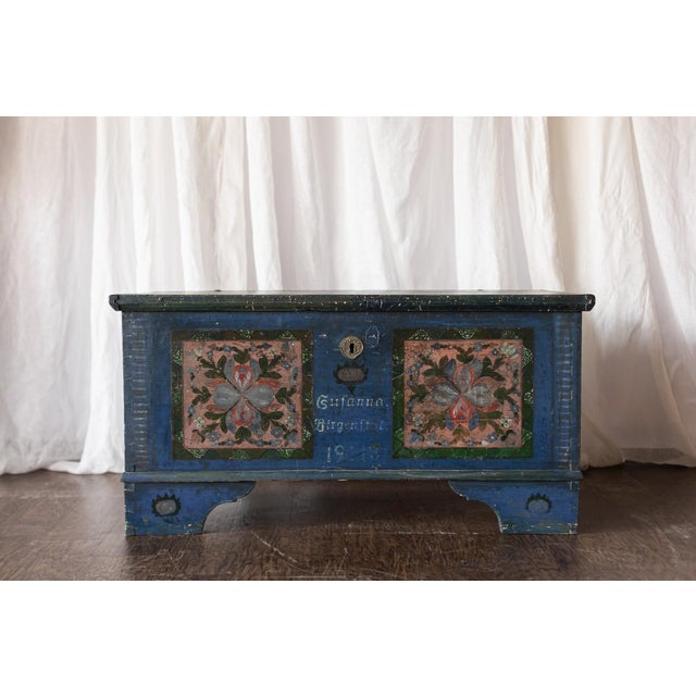 Description: This hand-painted European pine blanket chest features vibrant folk art floral panels and a rich blue ground,...