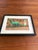 Whimsical and nostalgic framed color photograph featuring the iconic green Sinclair dinosaur posed beside a vintage “Dino”...