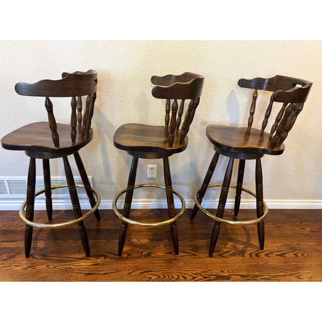 A matched set of three vintage Captain’s Mate swivel bar stools made in Yugoslavia. The stools have shaped solid wood...