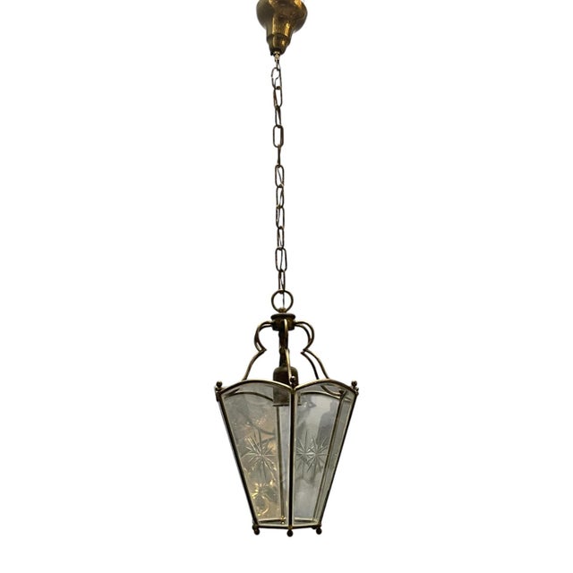 This elegant vintage lantern pendant light features a beautifully structured brass frame with a delicate, patinated...