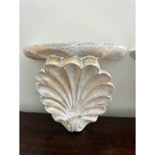 Plaster whitewashed gilt shell wall brackets, shelves. Straight out of the 1980s. Very nice decorative accents.