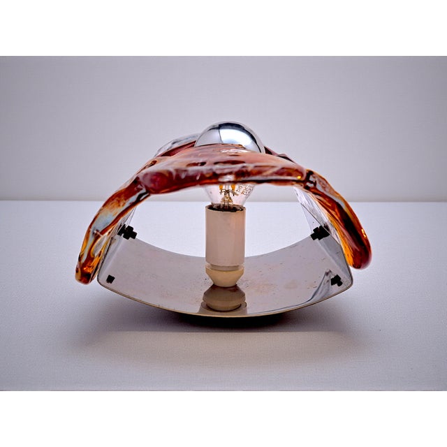 A pair of vintage wall lamps, dating back to the 1960s and 1970s, made in Murano, Mazzega. These wall lamps feature a...