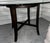 The table offers a circular glass top that is supported by a unique open-air wood base. Two crisscrossing stretchers...