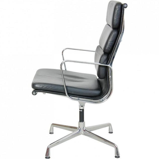 Charles Eames EA209 softpad chair upholstered in black leather, and with a chrome frame and armrests. The chair is from...