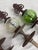 A sculptural trio of cast iron hose guards featuring crackle glass spheres in green and clear tones. Each piece combines...