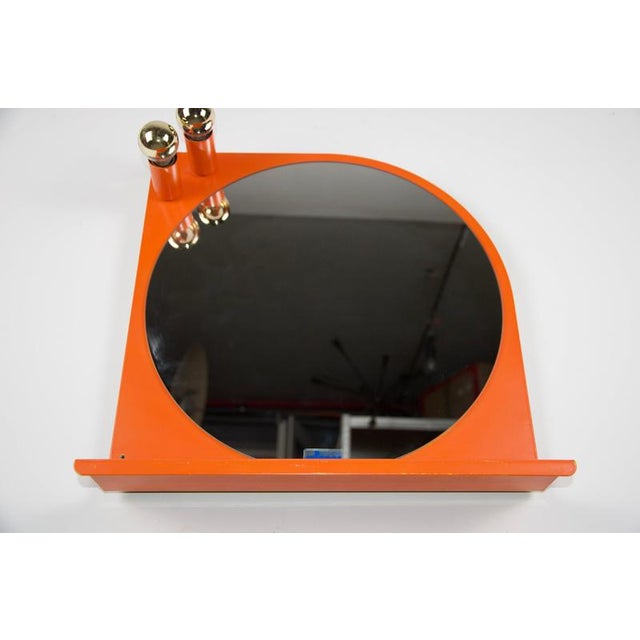 Orange illuminated wall mirror, Germany, 1970s. This bold vintage mirror features a round dark-tinted mirror plate set...