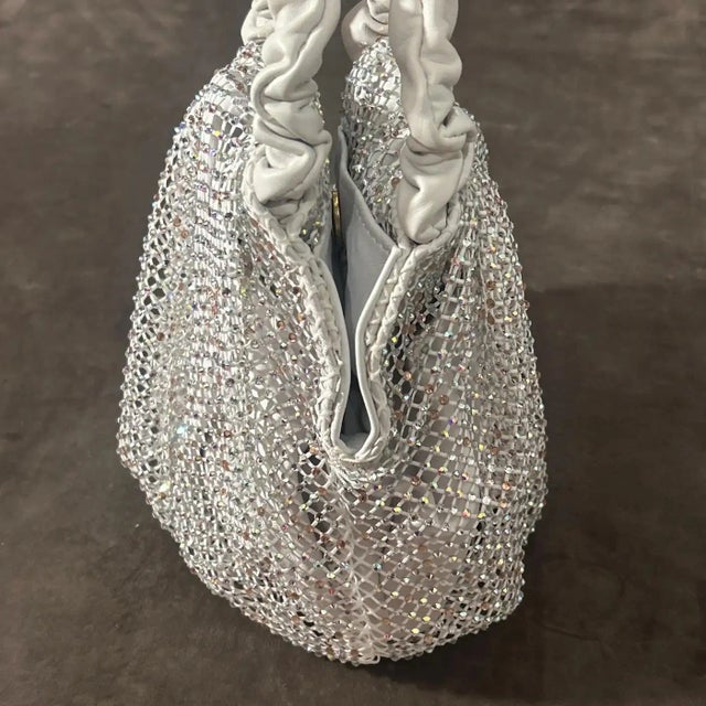 This Gedebe handbag embodies a blend of glamour and playful sophistication, showcasing the brand’s flair for combining...