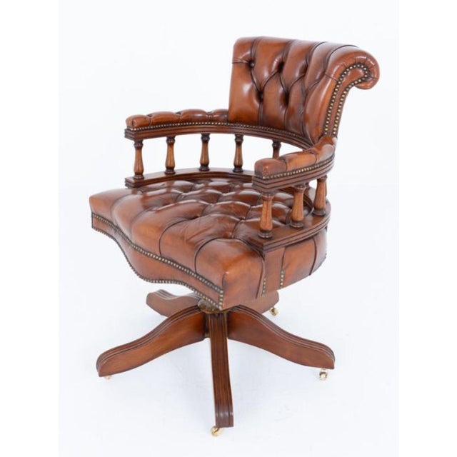 A fine and comfortable mahogany captains chair, raised on a shaped revolving base fitted with brass castors, combining...