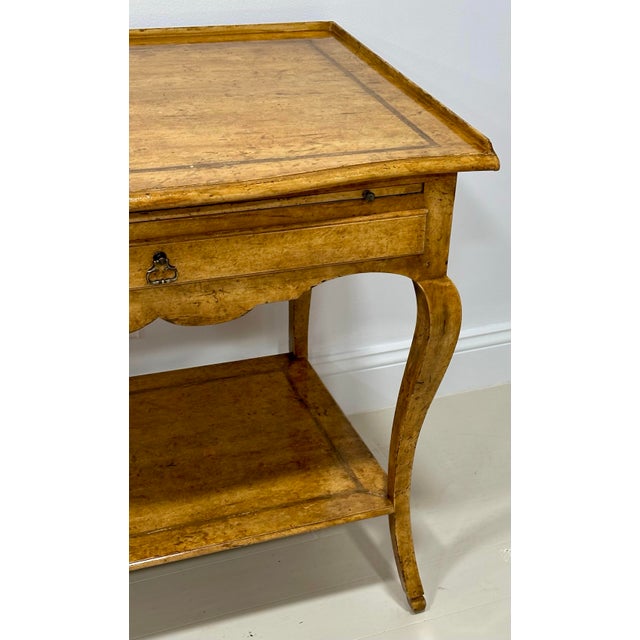 A beautifully crafted console table by Minton Spidell, this Regency-style console table features a hand-applied faux burl...