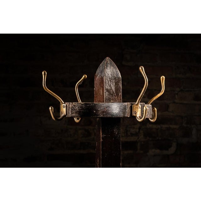 This mahogany coat tree features a dark finish with eight garment hooks. Four of these hooks are located at the top of the...