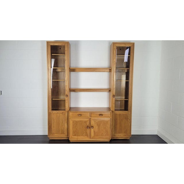 - Solid English elm sideboard with display cabinet - Produced by Ercol during the 1990s - Adjustable level feet - Original...