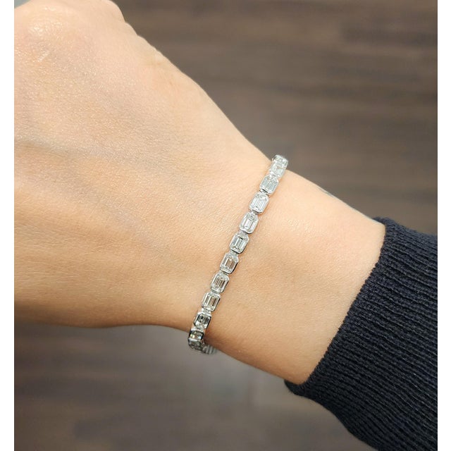 A sophisticated emerald-cut diamond tennis bracelet featuring 6.54 carats of 35 meticulously matched natural diamonds, set...