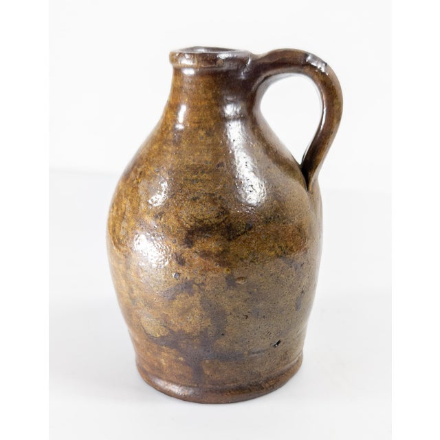 We are selling this attractive Miniature Redware glazed jug. This jug probably has a New England origin. The body is...