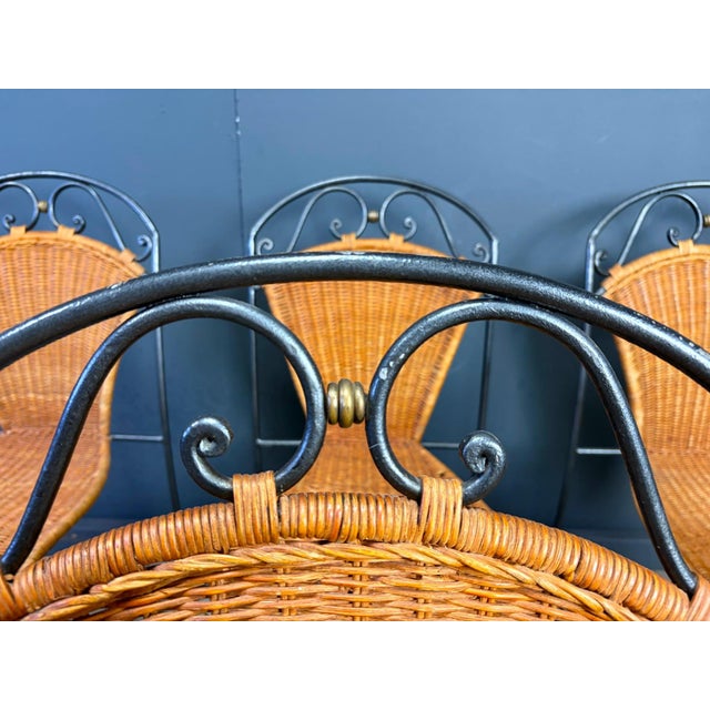 Vintage wrought iron and wicker bistro/dining chairs designed by Frederick Weinberg. Elegant black wrought iron frame with...