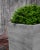 A cast stone planter with a woodgrain pattern in a Greystone finish. Available in multiple sizes, both square and...