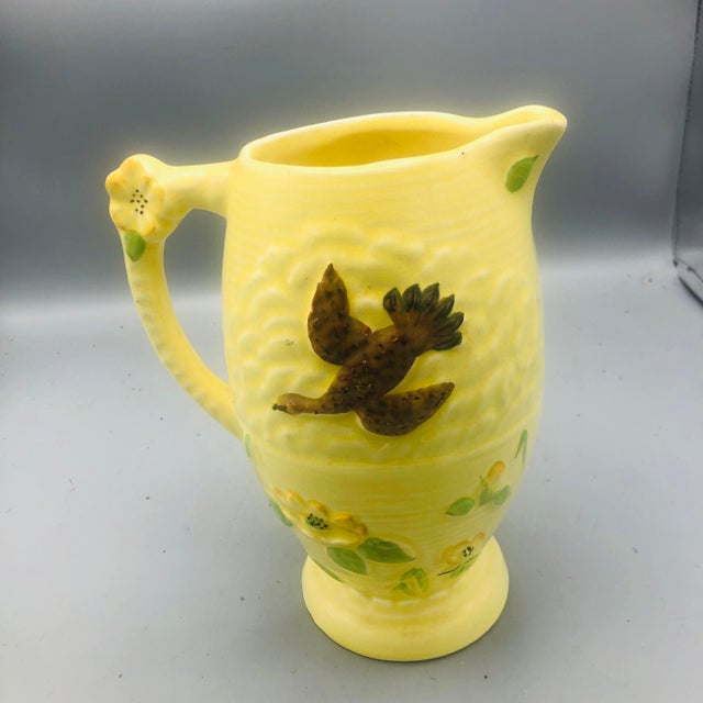A lovely Delcroft of England handled pottery pitcher . The vintage pitcher features flying birds and flowers with a flower...