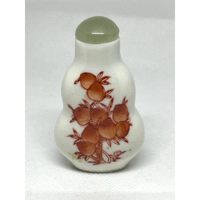 Early Chinese hand decorated red oxide paint on a white porcelain body. With green jade stopper and bone spoon. Measuring...
